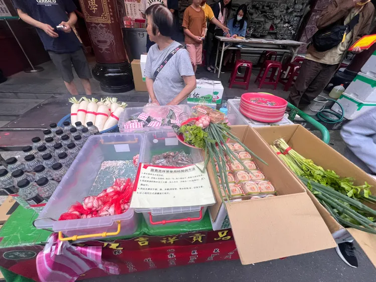 台北文昌宮前的小販販售「吉祥供品組」內含蔥、蒜頭、水、芹菜、桂花糕、龍眼乾、菜頭與富貴吉祥葉等象徵吉祥如意的供品，售價350元。黃泓哲攝