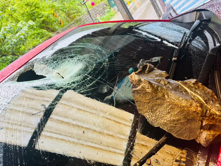 前檔靠近副駕駛座的位置遭落石擊中，幸好當時田妻與1個月大的兒子坐在後座。翻攝畫面