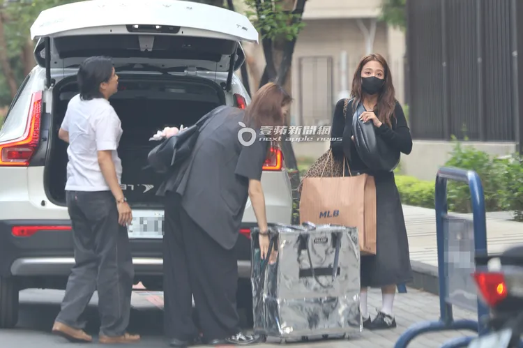 鬼鬼（右）到民生社區下車翻包找鑰匙，助理幫忙卸行李。特勤中心攝