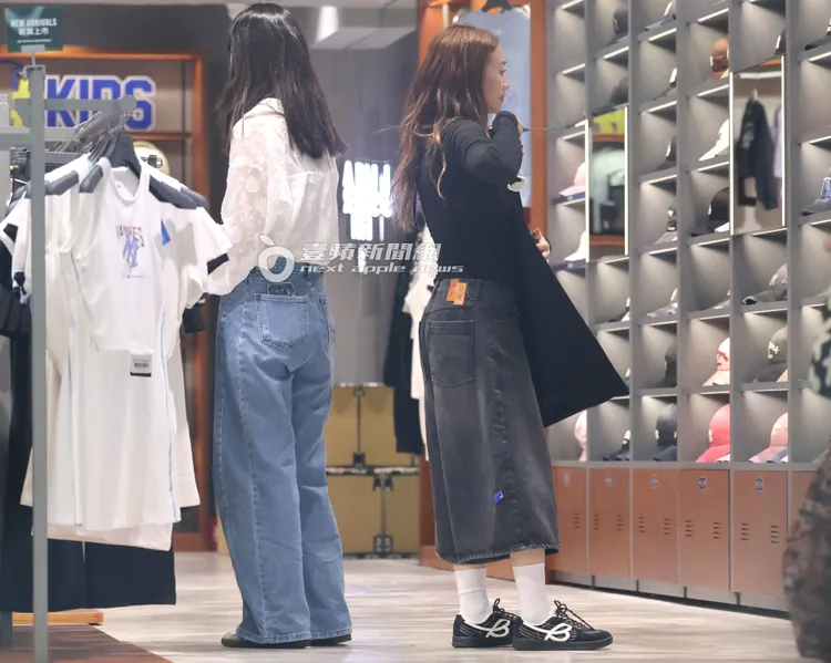 鬼鬼拿起另一件黑色連身裙在鏡子前想像穿起的樣子。特勤中心攝