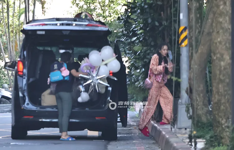 王思佳（右）邊講手機下車，保母幫忙搬花束和一堆氣球。特勤中心攝