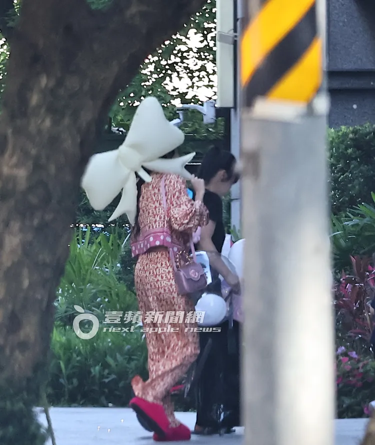 王思佳拿著蝴蝶結造型氣球，與女兒及保母回家。特勤中心攝