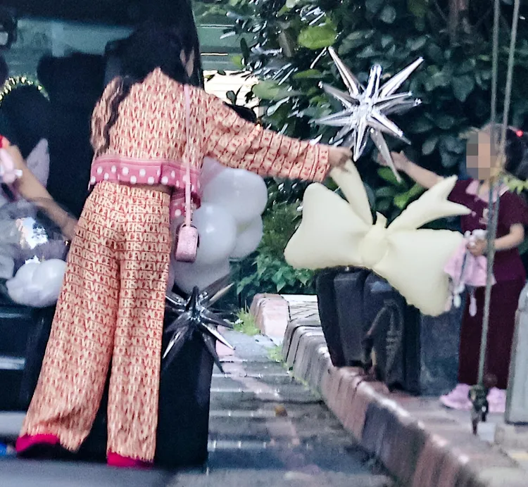 王思佳（左）將車上的造型氣球遞給女兒「小王美」（女兒衣服經變色處理）。特勤中心攝