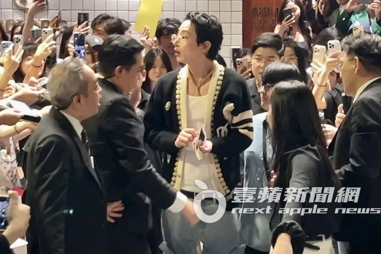 李洙赫拿了粉絲給的照片和筆準備簽名。特勤中心攝