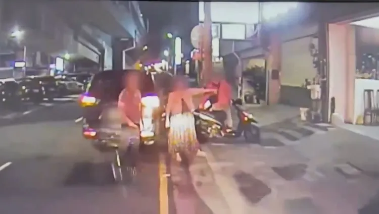 黃男逞凶後坐在機車上，冷眼看著哥哥和嫂嫂引導救護人員。翻攝畫面