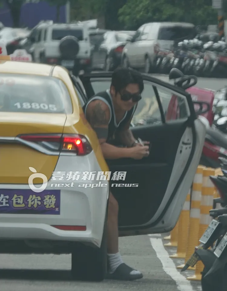 曹格手上拿著收據從計程車下車，準備返回工作室。特勤中心攝