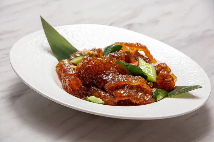 廣東順德經典涼菜「順德嗆魚皮」（280元），主廚汆燙後冰鎮魚皮，保留Q彈脆口質地，拌入香蔥、芫荽與芥末香醋，酸香微辣開胃，展現順德菜「鮮、爽、滑」的風味精髓，開胃又解膩。台北凱撒大飯店提供