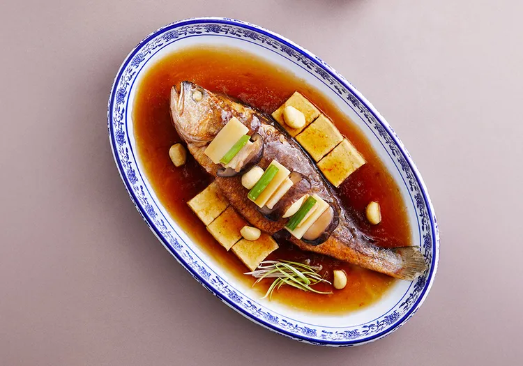 台南遠東香格里拉醉月樓餐廳「蒜子豆腐燒黃魚」是江南火候的經典演繹。5/26至5/30嘗鮮價988元，原價1380元。業者提供