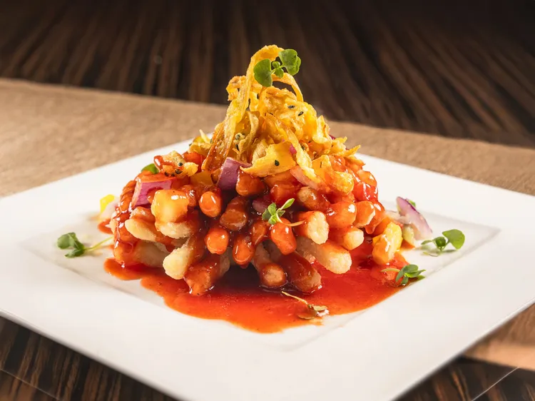 糖醋珊瑚咕咾肉選自黑毛豬松阪肉，經醃製12小時、200°酥炸金黃，澆淋糖醋醬綴頂。業者提供