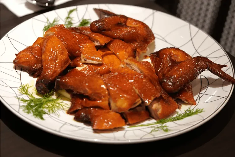 紅樓蒜香脆皮雞出菜前以150度熱油反覆澆淋至九分熟，吃起來外酥內嫩、蒜香四溢。瀚寓酒店提供