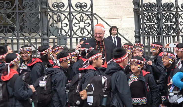 樞機主教穆勒（紅帽者）稱讚台灣原住民兒童表演非常成功，與兒童們親切互動合照。 中央社