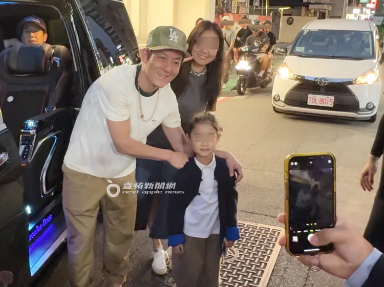 陳冠希（左）上車前抓緊時間和一對年輕母女合照，滿臉慈愛把手搭在小女孩肩上。特勤中心攝