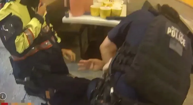 警員將袁嫌壓制在地，菜刀也掉在一旁。翻攝畫面