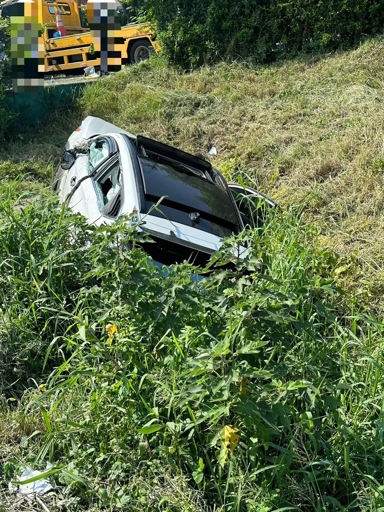 自小客車衝入國道匝道邊坡，卡在樹叢動彈不得。民眾提供