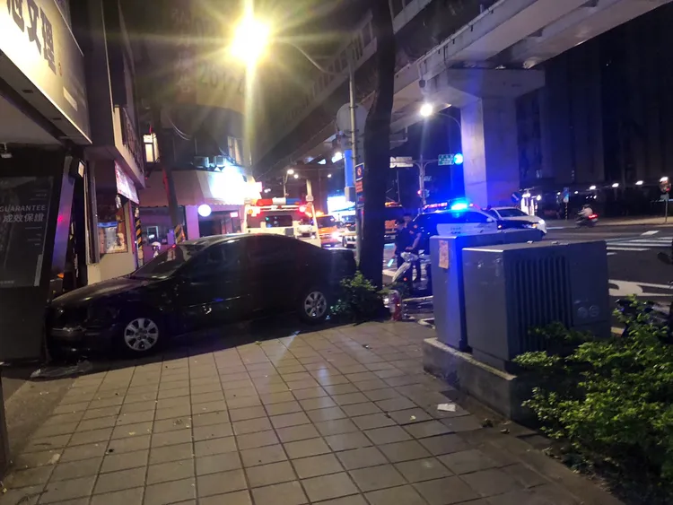轎車遭撞後衝進一旁人行道與騎樓。李易昌攝