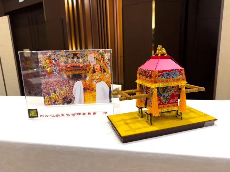 苗栗副縣長邱俐俐贈送象徵白沙屯媽祖「粉紅超跑」的轎子模型予日方，力邀日本旅客來台共赴朝聖之旅。台灣觀光協會提供
