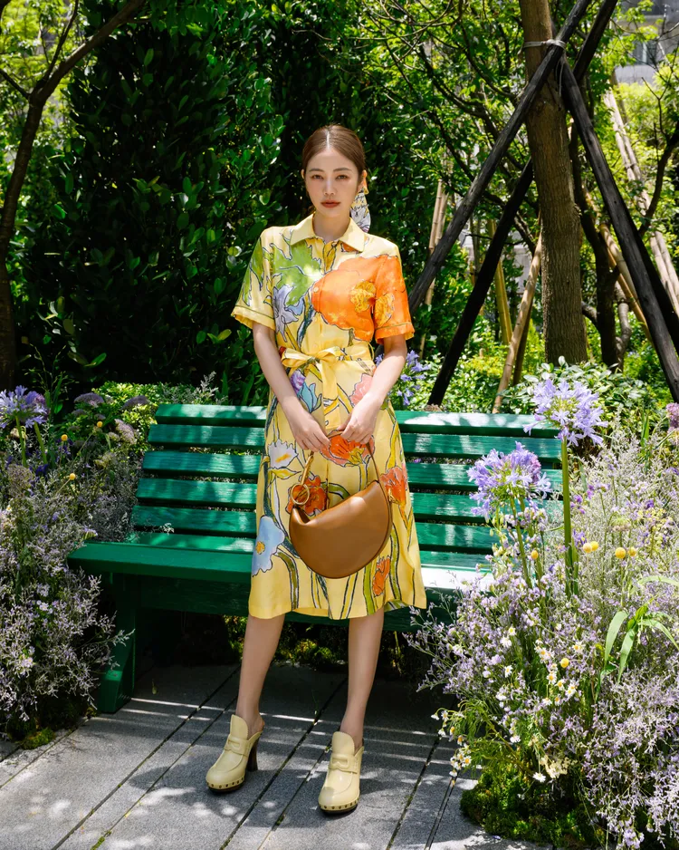 許路兒以一襲乳酪色印花洋裝搭配棕色Knight Arc包優雅亮相。品牌提供