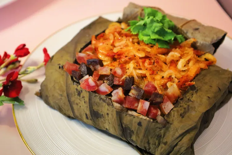 荷香櫻花蝦臘味糯米糕選用櫻花蝦、手工臘腸與香菇細火炒香，拌入口感紮實的優質糯米，再細心包裹於清香荷葉中蒸製，層層堆疊出節慶料理特有的古早味與土地的溫情。業者提供