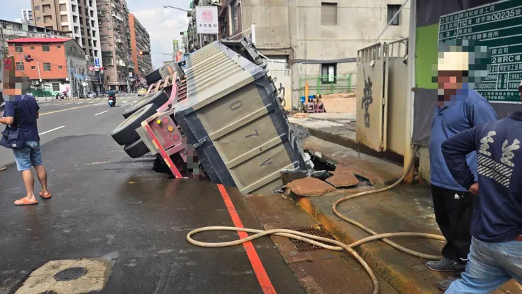 砂石車側翻卡在建案前「天坑」。翻攝畫面