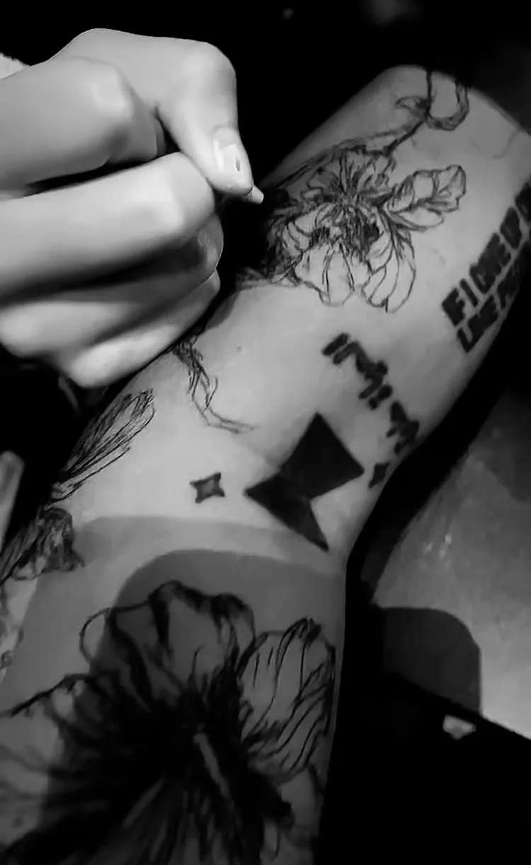 包子妹用筆在老爸曹格手臂上構圖。翻攝曹格Threads