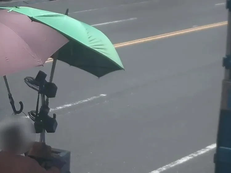騎士加裝2支大陽傘遮陽。翻攝畫面
