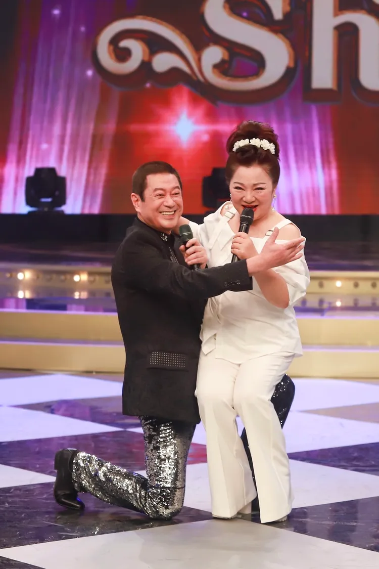 蔡小虎（左）邊唱邊跪下，白冰冰一屁股就坐在他腿上。民視提供