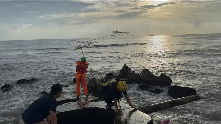 海巡出動船艇及安檢所人員，拋繩槍、下海救人。民眾提供