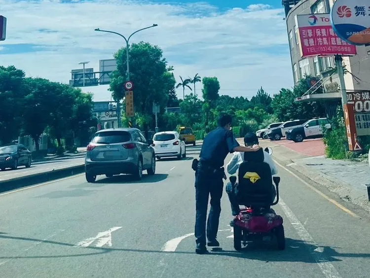 警員引導騎代步車的老翁到路邊。龍潭警分局提供