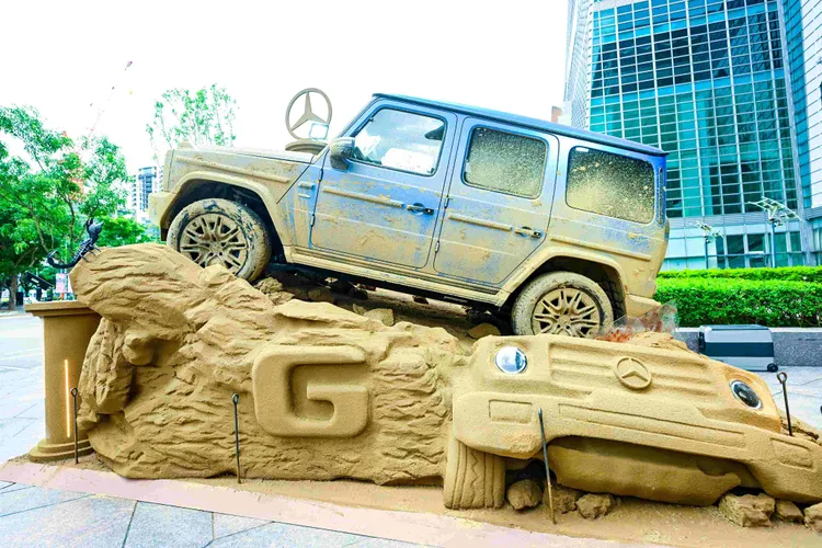 本次 G-Class 沙雕展台為 Mercedes-Benz 首度以戶外藝術形式展出車款，不採用常見的鋼鐵或岩石材質，而是選擇柔軟流動的沙石。業者提供