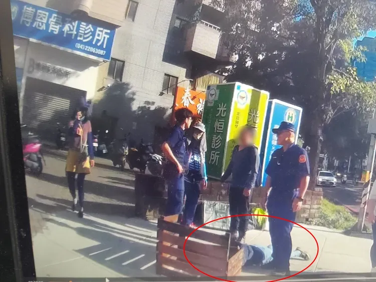 台中發生罷團與民眾肢體衝突事件，反罷免的鄧姓婦人（紅圈）趴在地上控遭對方毆打，志工則指控對方先搶奪旗桿。民眾提供