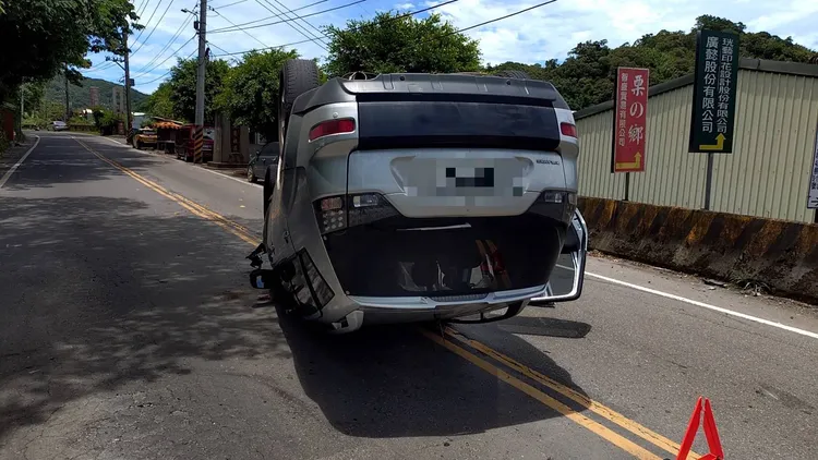 休旅車烏龜翻在路中，警方獲報趕抵協助交管。翻攝畫面