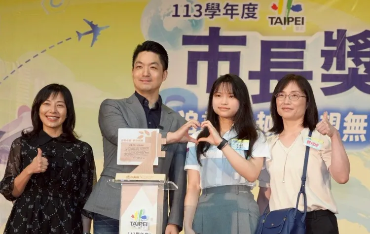 蔣萬安（右2）與獲獎同學開心比出愛心手勢合影。北市府提供