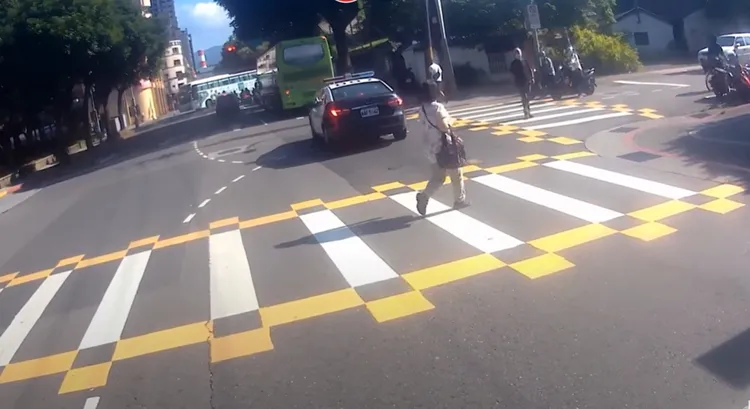 警車通過路口後，婦人還回頭看了幾眼。翻攝自WoWtchout - 地圖型行車影像分享平台