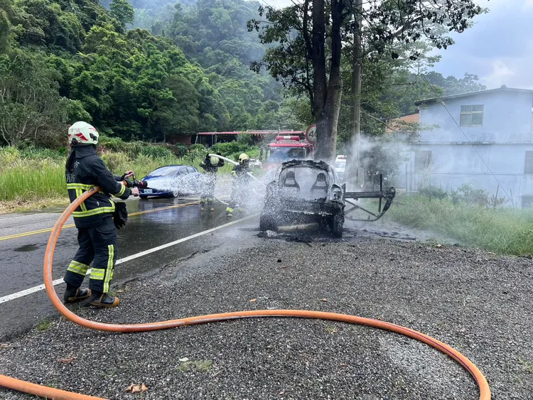 消防員射水滅火，車輛仍不斷冒出黑煙。翻攝畫面