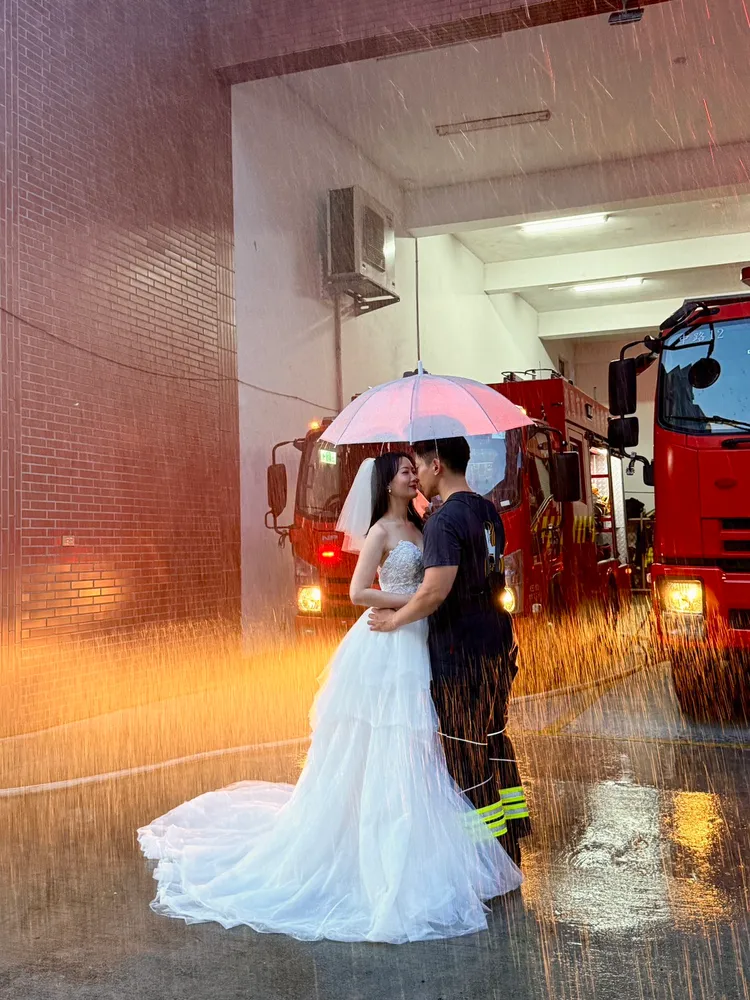 消防員和未婚妻深情對視，背後灑水製造浪漫氛圍。取自桃園市政府消防局中路分隊臉書
