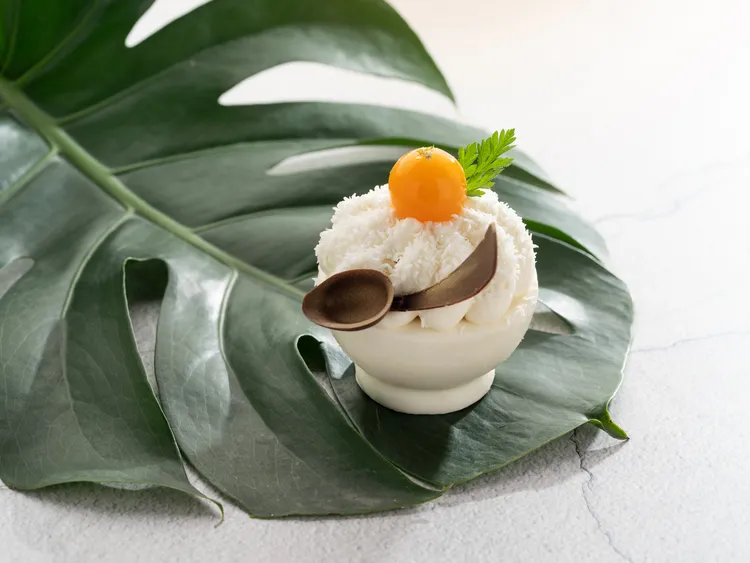 「文華餅房」推出「夏日芒果季」甜點饗宴「芒果刨冰」小蛋糕，濃醇馥郁的椰子奶霜與椰子蛋糕綴以檸檬芒果醬的酸香，與添入檸檬葉芬芳氣息的慕斯蛋糕相得益彰。台北文華東方酒店提供