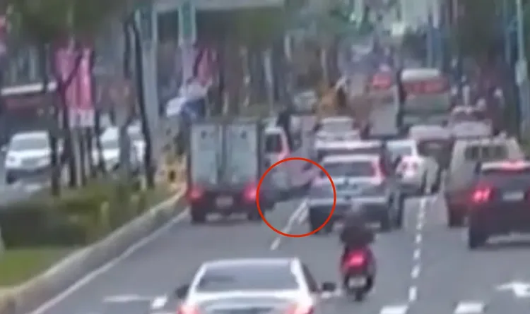 女騎士誤闖左轉車道後，跨越雙白線卻鑽車縫不慎擦撞摔車。翻攝畫面