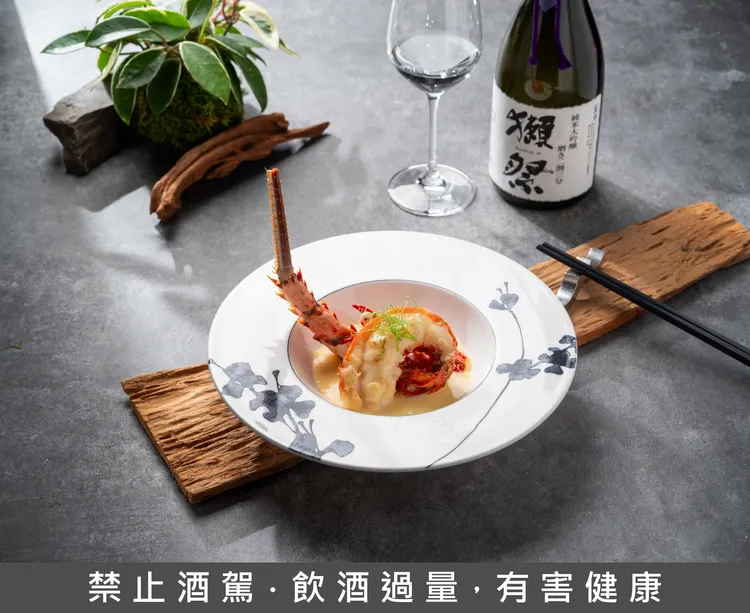 雅閣x獺祭「酩饗之夜」餐酒饗宴，「芝士牛油焗龍蝦」搭配帶著優雅香氣且酒質內斂的《獺祭二割三分 純米大吟釀》，巧妙襯托來自海洋的鮮美香潤。台北文華東方酒店提供