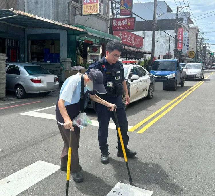警員攙扶老翁過馬路。大園警分局提供