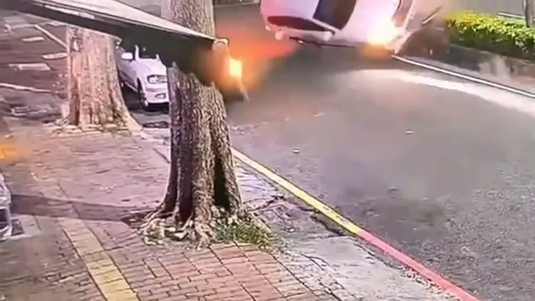 自小客欲切入內側車道時，自撞分隔島翻覆。翻攝畫面