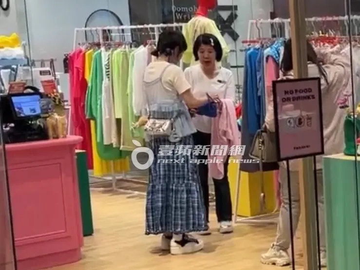 籃籃（左）拿起一件粉色衣服及藍色包包，詢問意見考慮一下。特勤中心攝