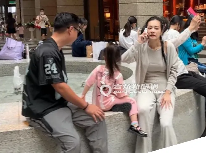 王思佳（右）不停講電話，Joe陪女兒看噴水池裡的水花。特勤中心攝