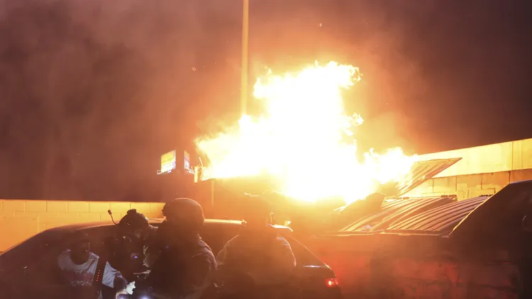 抗議民眾縱火燒車。美聯社