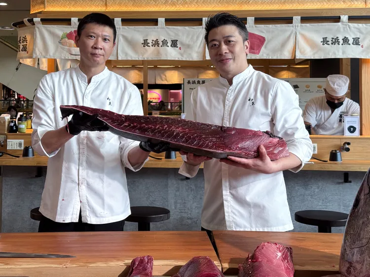 豊漁餐飲集團營運長黃永凱（右）與副總周家鴻（左）親自展演黑鮪魚分切秀。業者提供