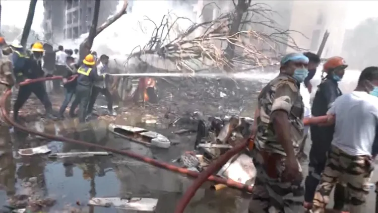 印度西部發生重大空難，墜機現場一片狼藉，搜救人員全力滅火。路透社