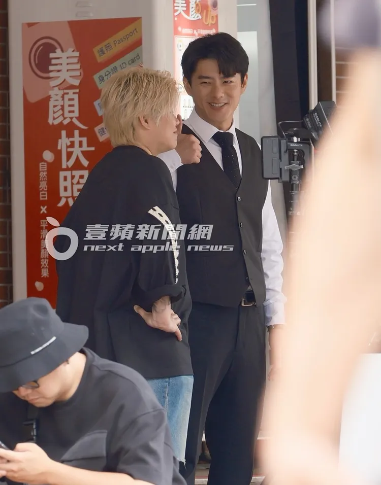 休息時，李程彬（右）與助理聊天，舉起大拇指比讚。特勤中心攝