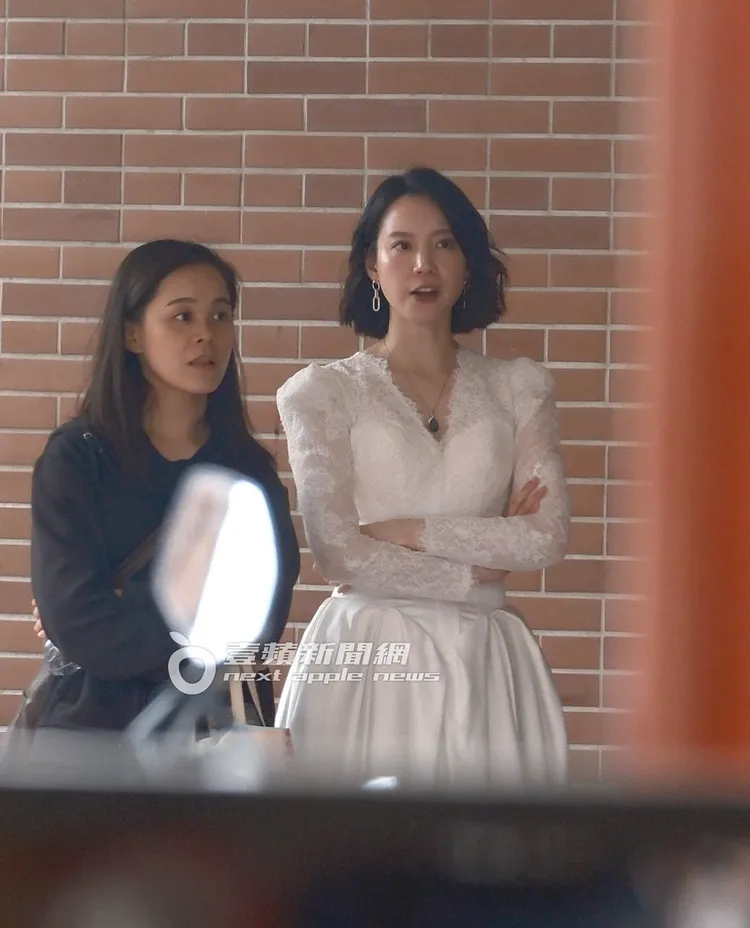 程予希（右）和工作人員在一旁躲太陽。特勤中心攝