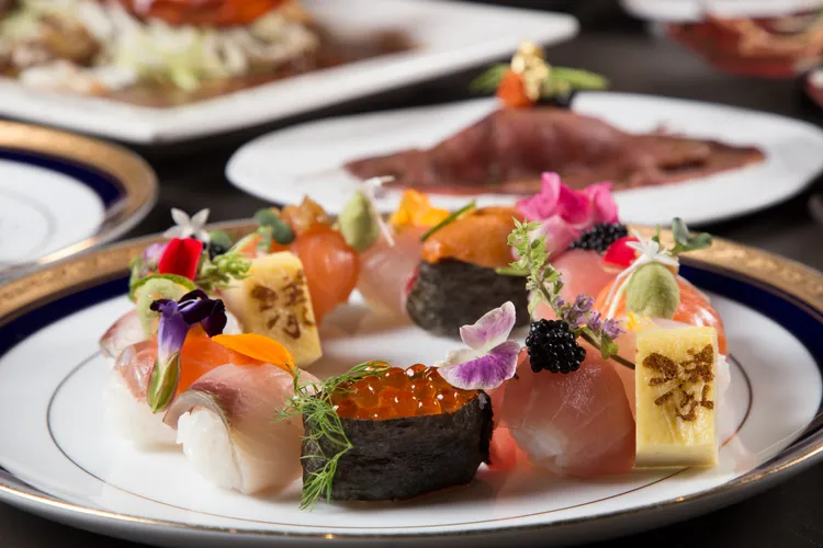 ▲漾客日式料理推出打卡拍照焦點的「馬卡龍壽司」，在壽司上頭點綴不同佐料，搭配金箔、魚子醬提升味覺和視覺，整盤有如花園般繽紛搶眼。