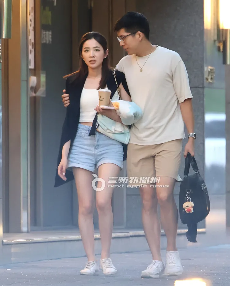 王乃伃手拿卡通圖案小毯子和外帶咖啡杯被男友摟住。特勤中心攝