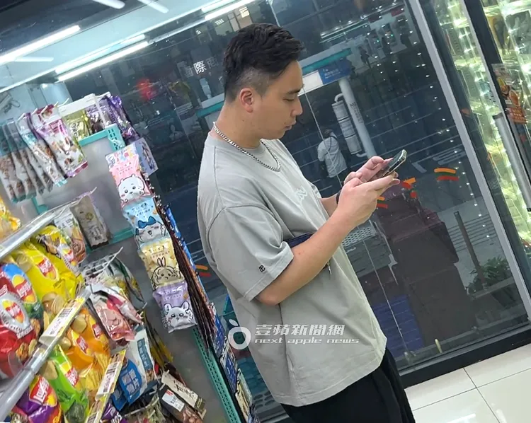 無尊在便利商店冰櫃前乘涼滑手機。特勤中心攝